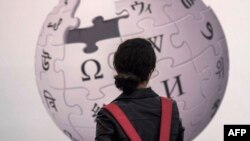 资料照:一名法兰克福书展的参观者站在维基百科的标识前。(2017年10月13日)