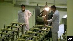 伊朗技术人员在生产铀燃料的设施前工作。(2009年4月9日)