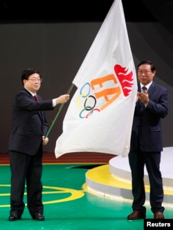 天津市长黄兴国在香港东亚运动会的闭幕式上挥舞东亚运动会会旗,下届东亚运动会在天津举行(路透社图片,2009年12月13日)