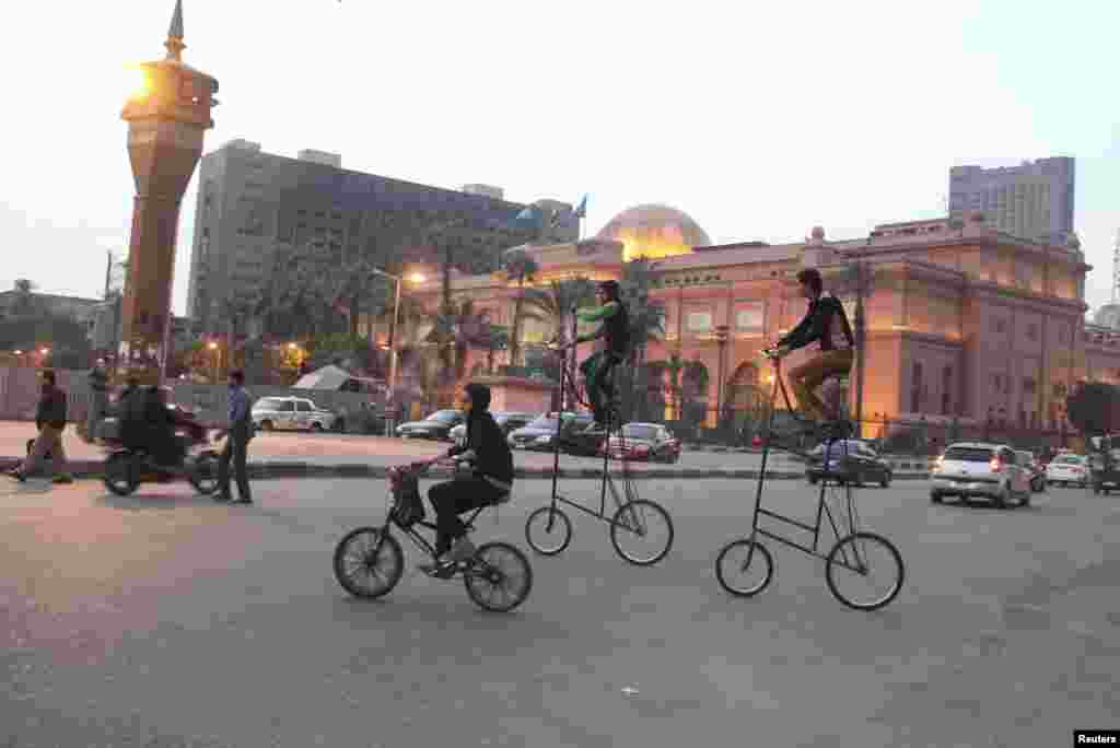 Hai thanh niên cưỡi xe đạp cao lêu nghêu tại quảng trường Tahrir ở trung tâm Cairo, Ai Cập.