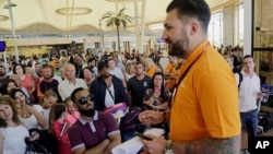 在埃及的沙姆沙伊赫机场,易捷航空的一名工作人员同滞留的旅客谈话 (2015年11月6日)