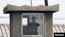 북한 접경도시 신의주의 국경 초소에서 북한 병사가 망원경으로 중국 쪽을 바라보고 있다. 압록강 너머 중국 단둥에서 촬영한 사진이다. (자료사진)