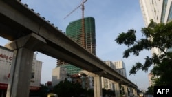 骑摩托车的人经过中国出资在河内修建的一处高架铁轨。(2014年9月12日资料照)