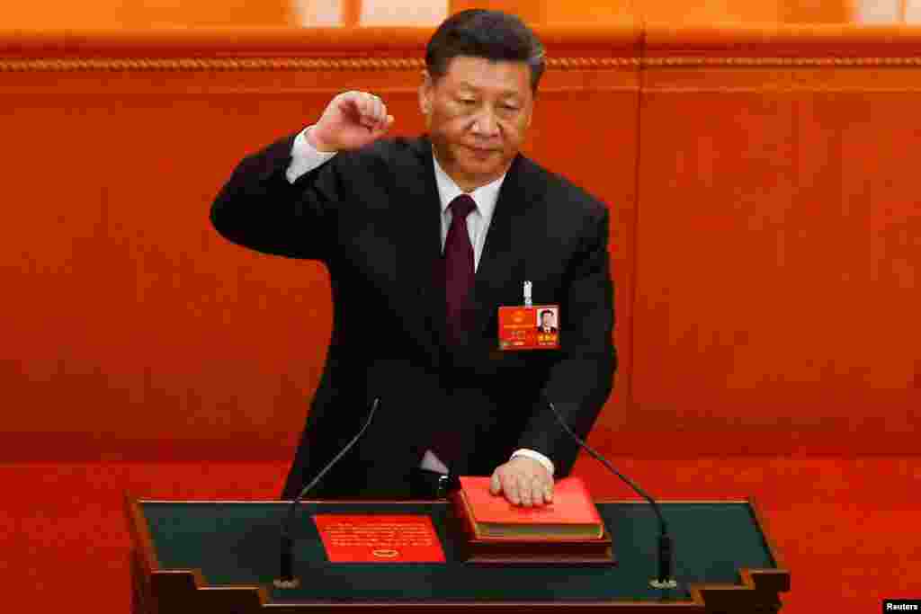 习近平左手抚按 他策划修改的新宪法 ,右手举拳,宣誓就任中国国家主席(2018年3月17日)。2013年习近平第一次当选国家主席时,还曾有一张反对票和三张弃权票。时隔五年,发出去的2970选票,零张反对、零张弃权,全部赞成。