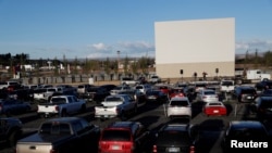 在美国科罗拉多州德尔塔市,人们坐在自己的车里举行了免下车复活节仪式。(2020年4月12日)