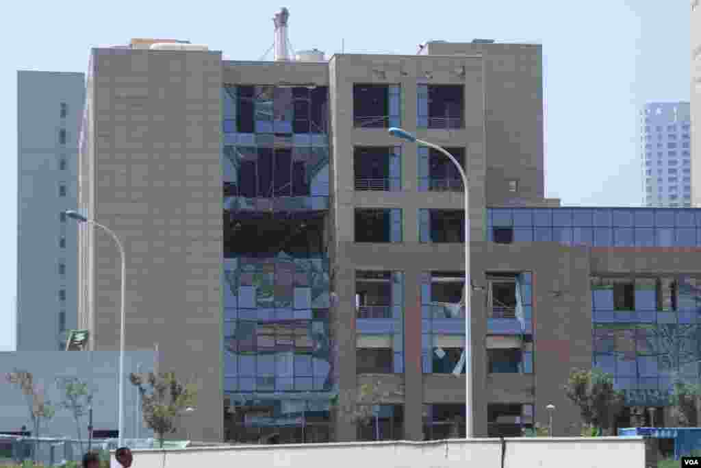 天津爆炸事故现场,核心爆炸区周围多座居民楼窗户被震碎,高速公路桥梁受损,多辆大货车被炸翻,小汽车起火或被砸,多名当地居民仍逗留在事故现场。(美国之音记者东方拍摄)