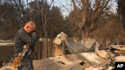 2025年1月9日,加利福尼亚州阿尔塔迪纳,西泽·普拉泽看着他的家被伊顿大火烧毁,抽泣不已。