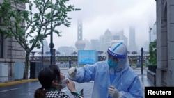 上海一名医护人员在对当地居民进行核酸检测（2022年4月26日）