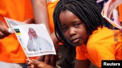 一名莫桑比克小女孩挥舞印有教宗方济各画像的旗子欢迎到访首都马普托的教宗。(2019年9月5日)