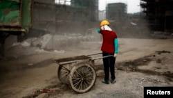 上海建筑工地前站着一名女农民工(资料照片)