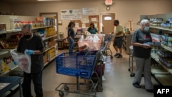 美国新墨西哥州的志愿者在一个食物库里准备装满食品袋捐助穷人。(2020年5月7日)