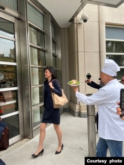资料照片:2024年9月25日,被控非法充当中共代理人的孙雯抵达布鲁克林联邦法院出席听证时,抗议者何岸泉试图将自制的盐水鸭递给她。(照片由何岸泉提供)