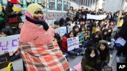 在韩国首尔日本大使馆前的一次集会上,学生们聚集在一个“慰安妇”雕像附近。 (2017年1月11日美联社资料照)