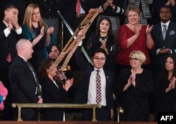 川普总统国情咨文演说特邀嘉宾池成镐在川普演说中提到他时站起身来挥舞拐杖致意。(2018年1月30日)