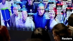 中国福建省福州市举办的中国数字技术展览会上参观者的脸部在人脸识别技术屏幕上显示。(2019年5月8日)