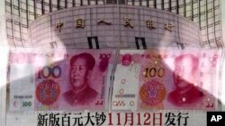 北京有人在街头报栏阅读报纸上关于中国央行宣布将发行百元新钞的消息(2015年8月11日)