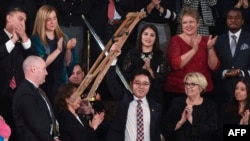 川普总统国情咨文演说特邀嘉宾池成镐在川普演说中提到他时站起身来挥舞拐杖致意。(2018年1月30日)