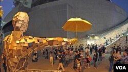 Bức tượng người đàn ông cầm cây dù được dựng lên tại địa điểm nơi họ dựng trại. Tuần trước những người biểu tình đã dùng những chiếc dù để tự vệ chống lại cảnh sát sử dụng hơi cay