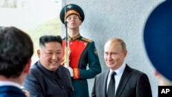 Presiden Rusia Vladimir Putin (kanan) dan pemimpin Korea Utara Kim Jong Un berjabat tangan dalam pertemuan di Vladivostok, Rusia, pada 25 April 2019. (Foto: Yuri Kadobnov/Pool Foto via AP)