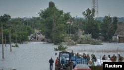 乌克兰卡霍夫卡水坝溃堤后救援人员正在向赫尔松地区的民众运送救援物资。(2023年6月12日)