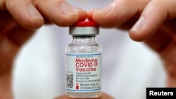 资料照片:美国康涅狄格州的一名药剂师展示一瓶莫德纳疫苗。(2021年2月17日)