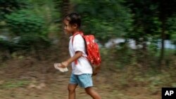 Một học sinh Campuchia trong vùng ngoại ô Phnom Penh chạy vội về nhà sau buổi học,