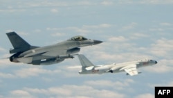 台湾F16战机监控伴飞在台湾南部巴士海峡上空飞行的中国空军H-6K轰炸机。(2018年5月11日)