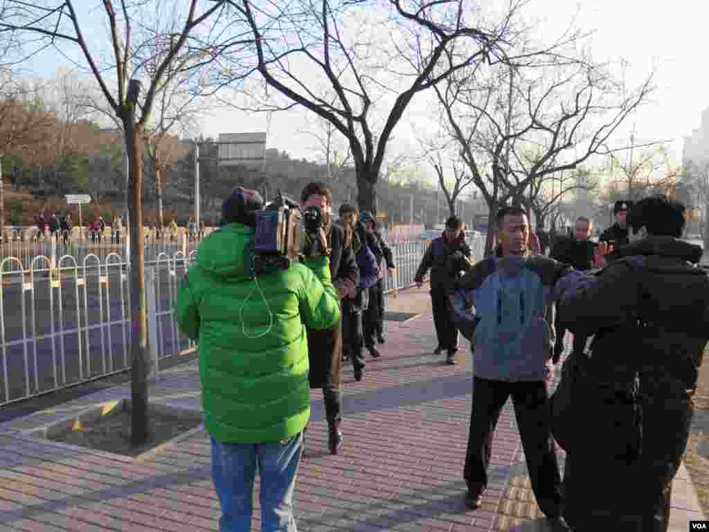 一身穿便衣的不明身份者上前制止外国记者拍照( 美国之音东方拍摄)