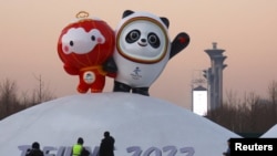 工人在北京冬奥会场馆树起冬奥会吉祥物冰墩墩和雪容融。(2022年1月11日)