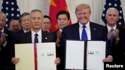 美国总统唐纳德·特朗普与中国副总理刘鹤在白宫签署美中第一阶段贸易协议。(2020年1月15日)