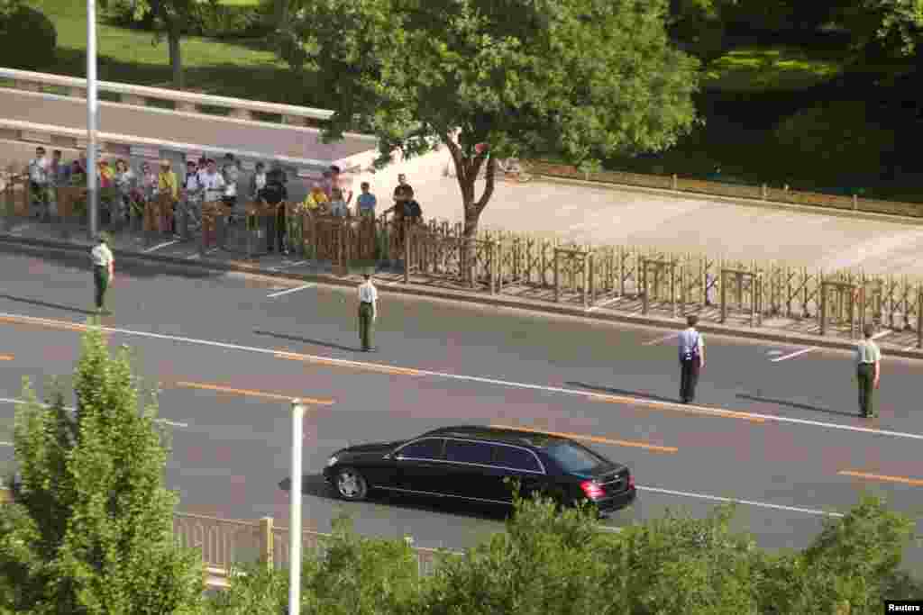 2018年6月19日,一列车队中的一辆汽车行驶在北京复兴门内大街,这被认为是朝鲜领导人金正恩的车队。这张照片是隔着窗户拍摄的。据信金正恩第三次访华是向中国领导人通报他与美国总统川普新加坡峰会的具体情况,也在下轮美朝高层会谈之前咨询北京。一些分析人士说,北京接二连三接待金正恩的目的之一是向外界展示中国能在迅速发展的朝鲜半岛无核化国际外交行动中扮演重要角色,而金正恩一再访华的目的之一是为自己在与美国的谈判中添加筹码。