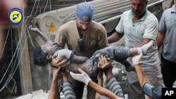 Thi thể của một em nhỏ được đưa ra khỏi đống đổ nát sau vụ không kích nhắm vào khu vực Sal-Shaar ở Aleppo, Syria, hôm 27/9.