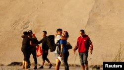 Sejumlah migran, yang di antaranya berasal dari Venezuela, berhasil menyeberangi sungai Rio Bravo untuk mencapai El Paso, Texas, pada 6 Oktober 2022, di mana mereka akan menyerahkan diri kepada pihak berwenang AS dan mengajukan suaka. (Foto: Reuters/Jose Luis Gonzalez)