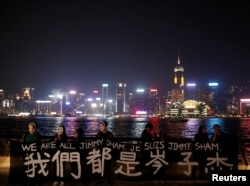 抗议者面罩岑子杰的面具手举标语在香港举行示威。(2019年10月18日)