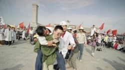 1989年5月16日,一名救护人员将一名绝食晕倒的北京大学生送出天安门广场。