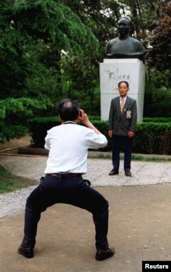 北京大学校友在中国最著名的教育家之一,北京大学前校长蔡元培的塑像前拍摄纪念照。