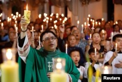 天主教神父邓友南10月26日晚间在越南义安省安城教堂内为英国卡车尸体惨案的39名死者举行烛光祷告仪式,有大约500人参加。