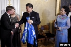 中国主席习近平和夫人在芬兰赫尔辛基参加国宴前,接受芬兰国家滑雪队赠送的运动衣(2017年4月5日)。习近平夫妇将从芬兰来到美国。