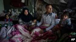 FILE - A family from Afghanistan gather at an abandoned building in Edirne, near the Turkish-Greek border, March 6, 2020.