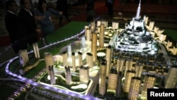 参观者在围观“马来西亚城”(Bandar Malaysia)混合商业项目的模型。(2019年12月17日)