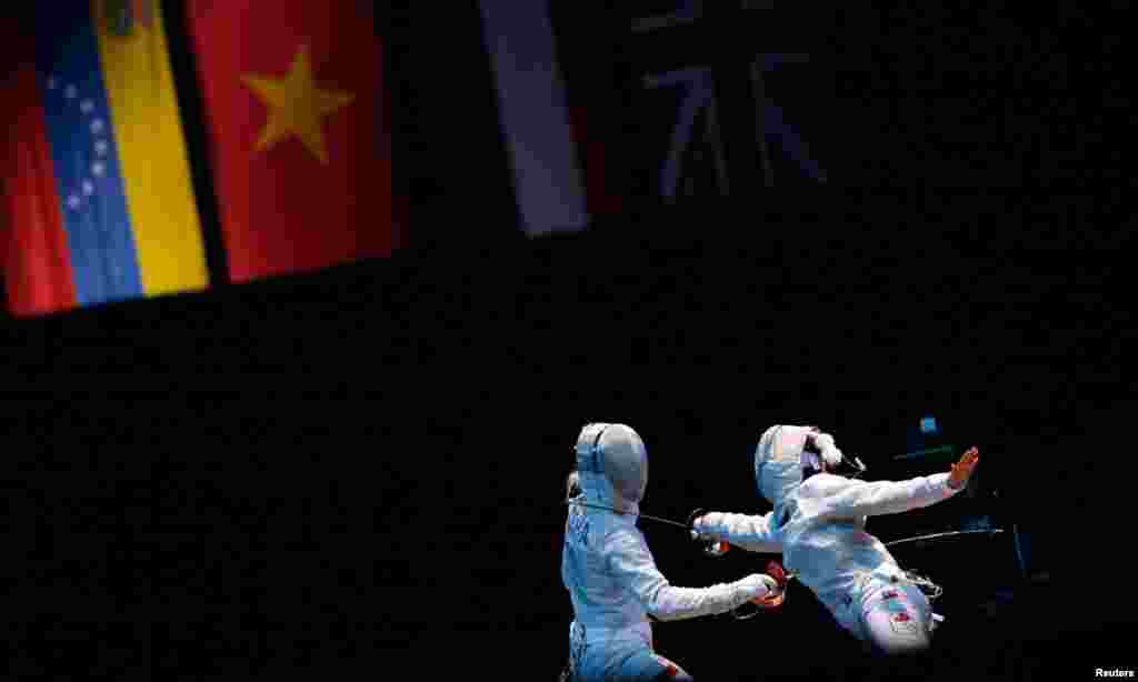 Vận động viên Aleksandra Socha người Ba Lan (phải) đấu với vận động viên Sandra Sassine người Canada trong trận đấu kiếm chém cá nhân nữ vòng 32 tại sân đấu ExCel.