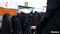 2019年3月31日,霍尔营地的伊斯兰国妇女排队领取物资