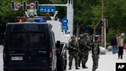 2014年5月23日,中国新疆首府乌鲁木齐的街道上戒备森严,武警部队的装甲车停在街上,武警战士在各处警戒。