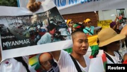 A woman closes her eyes as she joins tens of thousands of people attending a candlelight vigil at Victoria Park in Hong Kong to mark the 25th anniversary of crackdown in Tiananmen Square, June 4, 2014.