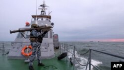 一名乌克兰军人肩扛便携式防空武器“毒刺”在乌克兰海事警卫队在西北部黑海的一艘巡逻船上扫描空中目标。 (2023年12月18日)