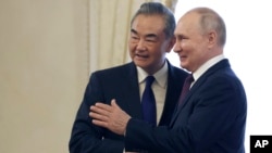 资料照片: 2023年9月20日俄罗斯总统普京(右)与中国外交部长王毅在俄罗斯圣彼得堡君士坦丁宫会面