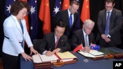中国商务部长高虎城(左二)和澳大利亚贸易部长安德鲁·罗布(右二)在堪培拉签署中国澳大利亚自由贸易协定。澳大利亚总理艾伯特(后排中)目视