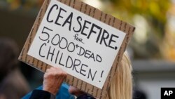 Seorang demonstran memegang poster yang berisi seruan gencatan senjata dalam perang Israel-Hamas pada aksi protes yang digelar Jewish for Peace di Space Needle, Seattle, pada 19 November 2023.