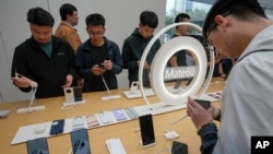 北京华为专卖店的新品发布会上,顾客试用华为最新的可折叠设备Mate X5和Mate 60系列手机。(2023年9月25日)