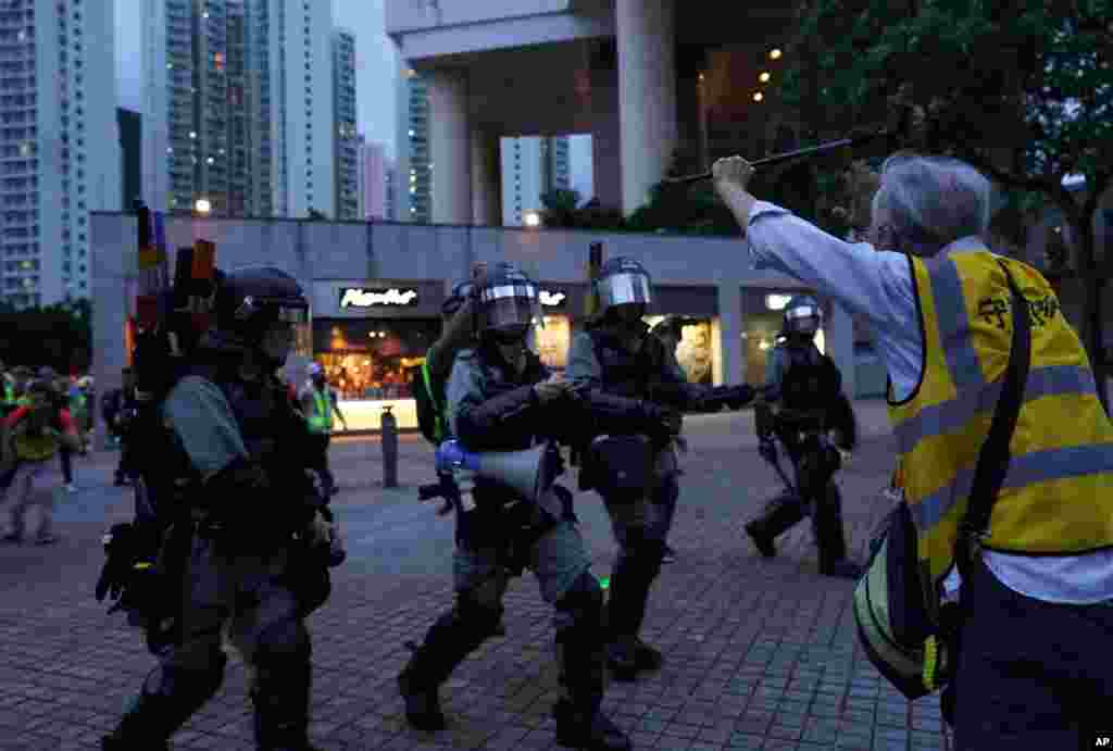 抗议者围堵机场外公路。港铁关闭所有进出机场的线路。在东涌站外,一位老者试图拦阻要逮捕抗议者的警察。(2019年9月1日)